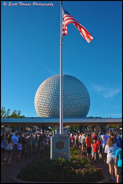 People lined up on either side of the dedication plaque flagpole outside Epcot on October 1, 2012, Walt Disney World, Orlando, Florida.