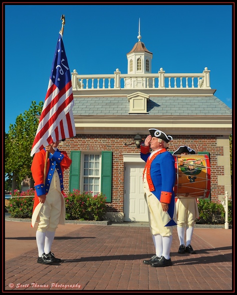 Member of the Spirit of America Fife and Drum Corps saluting the American flag in front of the American Adventure in Epcot, Walt Disney World, Orlando, Florida.