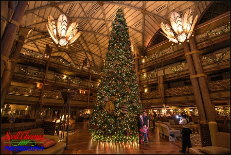Photopass photographer photographing guests in front of the Christmas tree at Disney's Animal Kingdom Lodge, Walt Disney World, Orlando, Florida