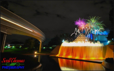 A monorail passes Journey into Imagination's Reverse Waterfall as Illuminations fireworks explode overhead in Epcot's Future World, Walt Disney World, Orlando, Florida