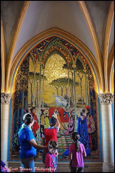 A family stops to view a mural in Cinderella Castle archway at the Magic Kingdom, Walt Disney World, Orlando, Florida