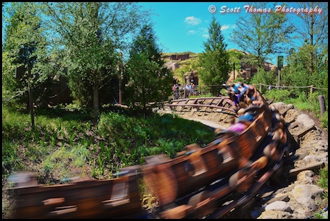 Seven Dwarfs Mine Train flying by in Fantasyland at the Magic Kingdom, Walt Disney World, Orlando, Florida